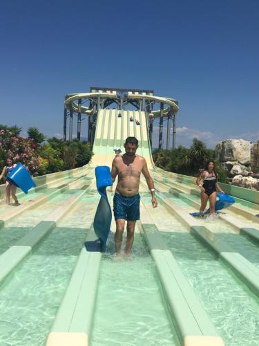 Ein Mann steht auf einer Rutsche in einem Wasserpark. in der Unterkunft Chambre chez habitant résidence piscine in Carpentras