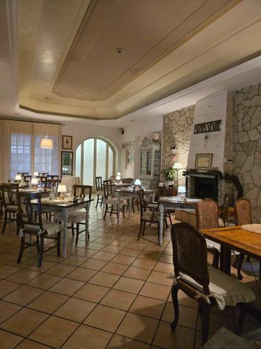 a restaurant with tables and chairs and a fireplace at Hotel Pineta Ristorante country house in Fabriano in Campodonico