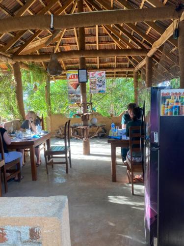 a group of people sitting at tables in a restaurant at Hotel Hanguk Villa in Dambulla