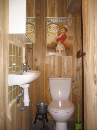 La salle de bains est pourvue de toilettes, d'un lavabo et d'une affiche. dans l'établissement Joli appartement de village, à Boussy