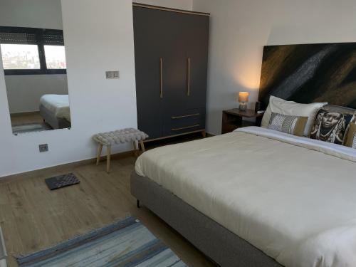 a bedroom with a large bed and a mirror at Kalia 3 bedrooms, superb aerial view, pool, fitness in Dakar