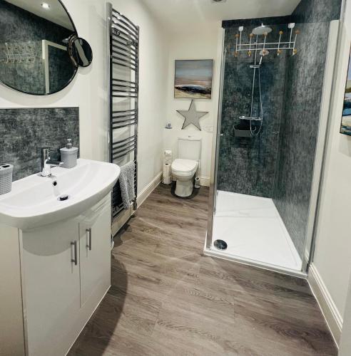 a bathroom with a shower and a sink and a toilet at Cosy Cottage in Stirling