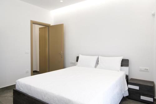a bedroom with a white bed with white sheets at Maistros Apartments Mykonos in Elia