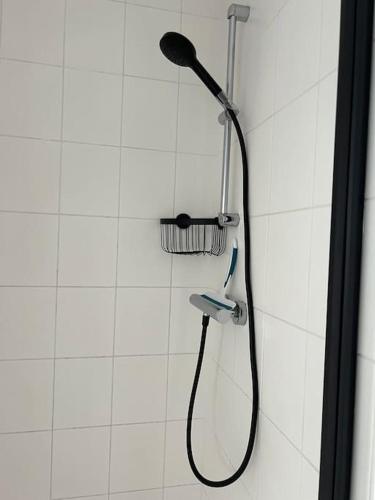a shower with a shower head and a toothbrush at La Pointe d'Opale Maison 6 personnes à Wimereux in Wimereux