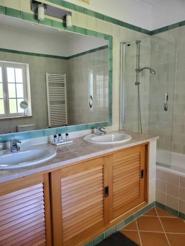 a bathroom with two sinks and a large mirror at Cantinho da Carminho in Amoreira