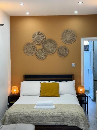 a bedroom with a bed with four plates on the wall at Flat in Camden Kings Cross in London