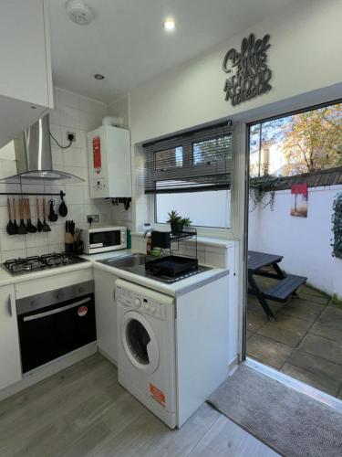 a kitchen with a washing machine and a stove at Flat in Camden Kings Cross in London
