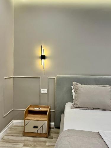 a bedroom with a bed and a nightstand next to a bed at Spiranca Luxury Suites in Tirana