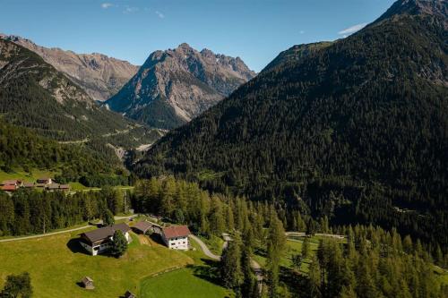 a house in the middle of a valley with mountains at Berghaus Panorama in Bschlabs