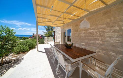 a patio with a wooden table and chairs at Awesome Home In Sumartin in Sumartin