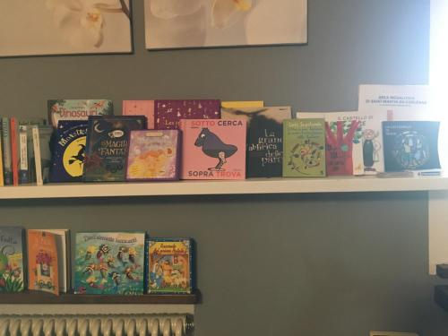 a shelf filled with books on a wall at La casa del bosco in Aosta