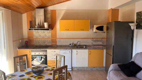 a kitchen with yellow cabinets and a table in a room at CA LIDIA-Apartamentos Turísticos EL CAMPANAR 1 in Benimantell