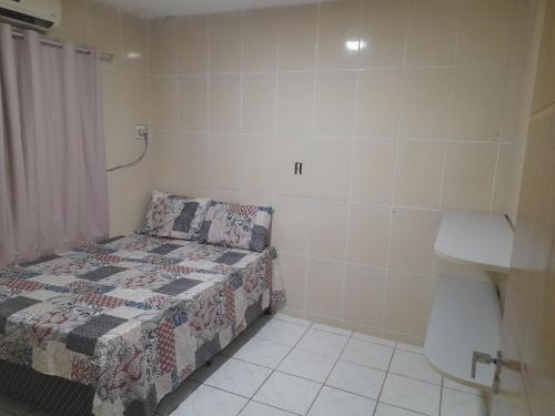 a small bedroom with a bed and a sink at Casa em cidade universitária in Maceió
