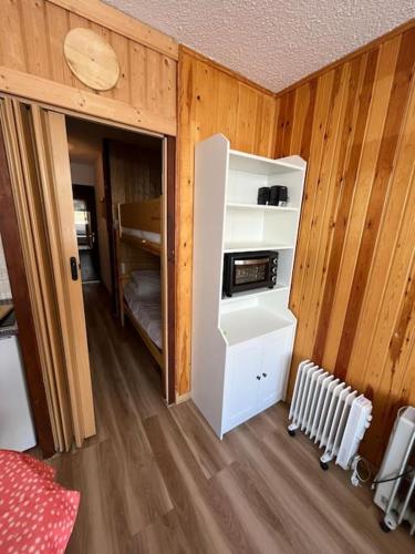 Cette chambre est dotée de murs en bois et d'un réfrigérateur. dans l'établissement Club Engaly I - Pied des pistes, à Le Plan