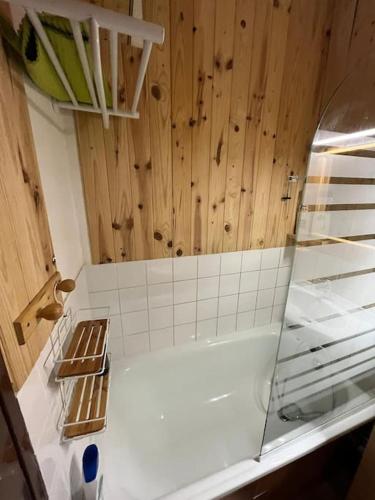 - une cuisine avec un comptoir blanc et des murs en bois dans l'établissement Club Engaly I - Pied des pistes, à Le Plan