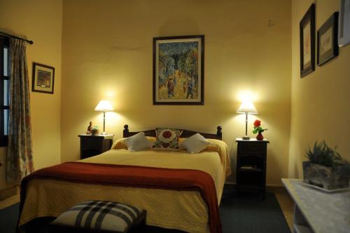 a bedroom with a large bed with two lamps at Finca Cielo Verde in Chicoana