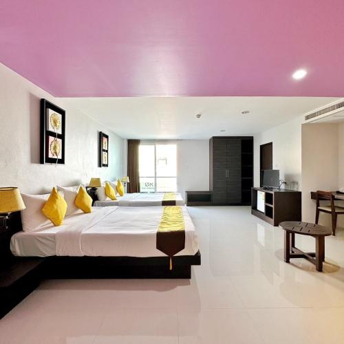 a bedroom with a large bed with a purple ceiling at Twin Hotel in Phuket