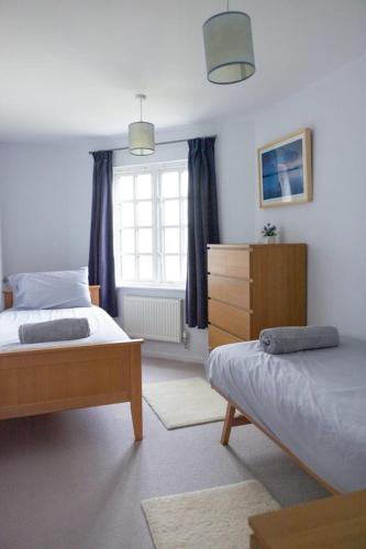a bedroom with two beds and a dresser and a window at Hello !! and welcome to Solius Lodge in South Cerney