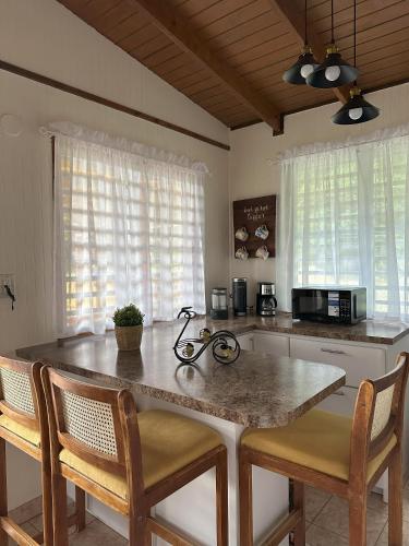a kitchen with a counter with two chairs and a counter top at La Casita Amarilla en Utuado, Puerto Rico in Utuado