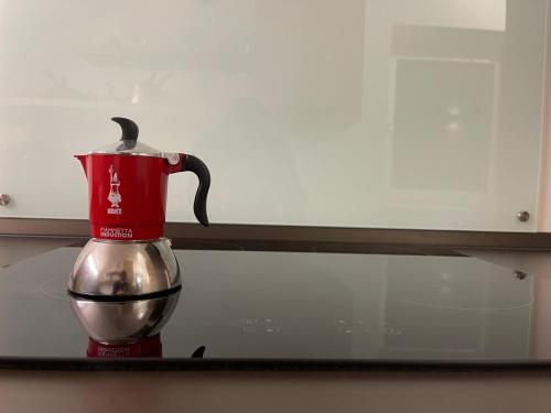 a red coffee maker on a counter with a mirror at SnowLake Suite & Apartment in Alleghe