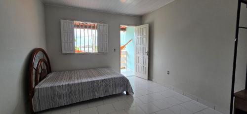 a room with a bed and a window and a door at Vila Mar Flats - 1 Dorm - Guriri - 800m da Praia in Guriri