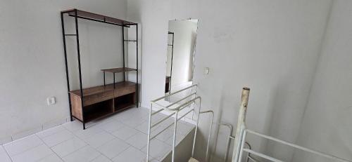 a white room with a staircase and a mirror at Vila Mar Flats - 1 Dorm - Guriri - 800m da Praia in Guriri