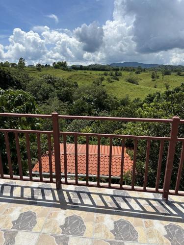 a balcony with a view of a field at La Casita Amarilla en Utuado, Puerto Rico in Utuado