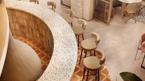 a bar with a row of stools in a room at Secrets Baby Beach Aruba Adults Only in Ceru Colorado