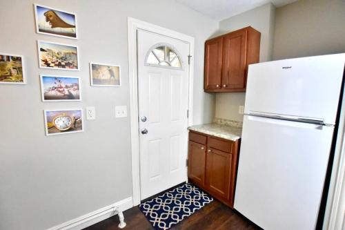 a kitchen with a white refrigerator and a door at Lake Avenue Apartment in Cleveland