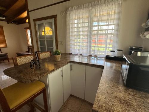 a kitchen with white cabinets and a counter top at La Casita Amarilla en Utuado, Puerto Rico in Utuado