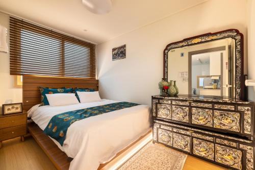 a bedroom with a bed and a large mirror at Choi's Stay HongDae in Seoul
