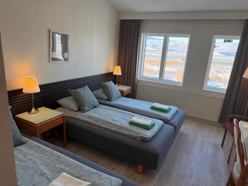 a living room with a couch and two windows at Frost Guesthouse in Hvammstangi