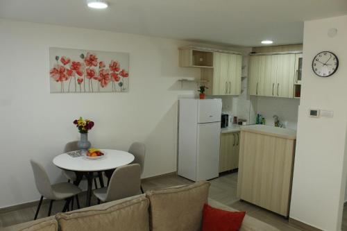 a small kitchen with a table and a white refrigerator at Zemun Residence in Belgrade