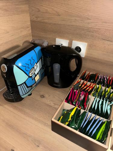 - une table avec une tasse de café et une boîte de stylos dans l'établissement O Sand Stras Studio 25m carré, à Strasbourg