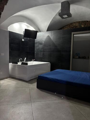 a bedroom with a bed and a tub and a sink at HomeSuite45 in Catania