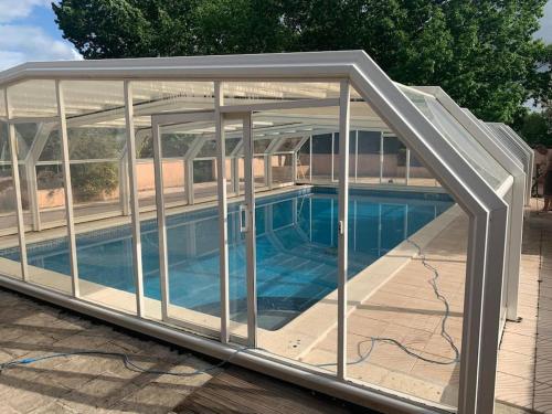 a greenhouse with a swimming pool inside of it at Maison familiale avec piscine proche Périgueux in Chancelade