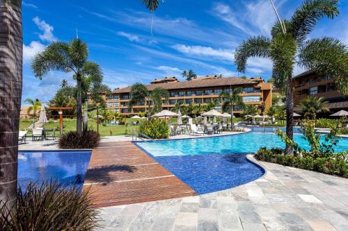 a resort swimming pool with a resort in the background at Flat Colina - Eco Resort Praia dos Carneiros in Tamandaré