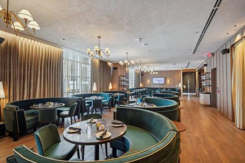 a restaurant with green chairs and tables and a bar at NEW Luxury Bay View Downtown 1 Bedroom in Miami