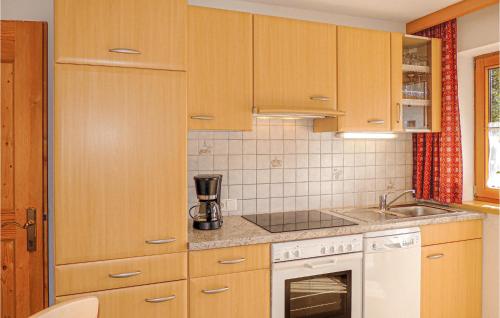 a kitchen with wooden cabinets and a white appliance at Schoene Ferienwohnung-Aschau in Aschau