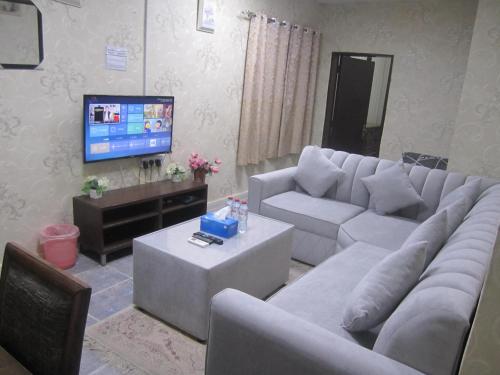 a living room with a couch and a tv at العين الهيلي مصباح ب 7 in Al Ain