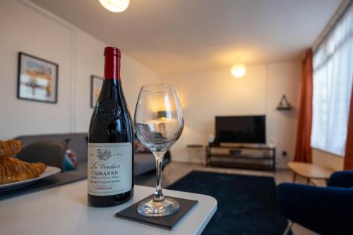 a bottle of wine sitting on a table with a wine glass at Entire 3 Bedroom Apartment in Felixstowe in Felixstowe
