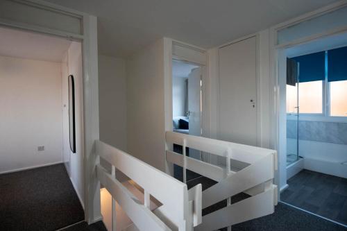 a white room with a staircase and a refrigerator at Entire 3 Bedroom Apartment in Felixstowe in Felixstowe
