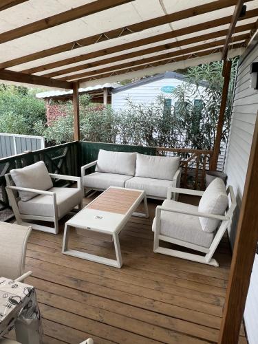 d'une terrasse avec des canapés et une table basse. dans l'établissement Camping Del Mar 265, Mobile Home Excellence, 3 chambres, 6 personnes, 2 Salles de Bain, bord de mer, à Argelès-sur-Mer