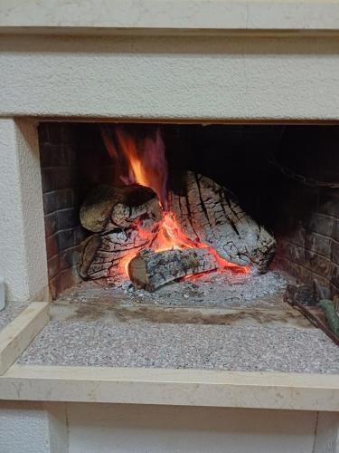 a brick fireplace with a fire in it at Dimitris House in Pramanta