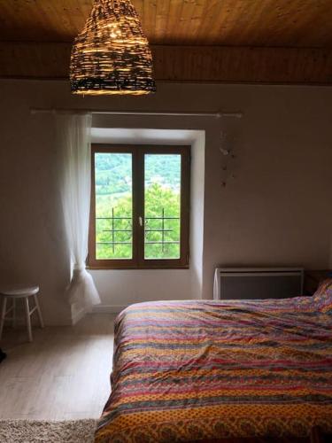 une chambre avec un lit et une fenêtre dans l'établissement Maison de village avec jardin, à Saint Firmin