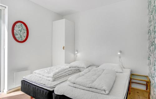 a white bedroom with a bed with pillows on it at Beautiful Home In Sjællands Odde in Yderby