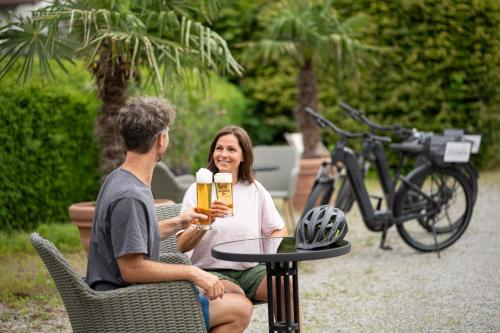 a man and a woman sitting at a table with a beer at Hotel Filser in Füssen