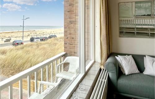 a balcony with a couch and a view of the beach at Zwaluwnest in Bergen aan Zee