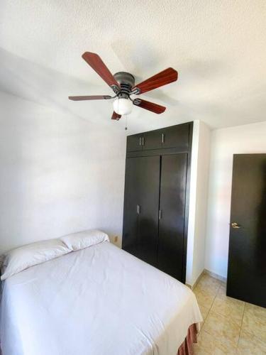 a bedroom with a ceiling fan and a black cabinet at Casa Primavera in Tuxtla Gutiérrez