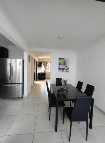 a dining room with a table and a refrigerator at Casa Primavera in Tuxtla Gutiérrez